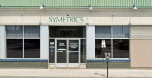 The exterior of the Symetrics office with doors and signage